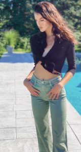 Image of Maddie wearing green jeans by a pool