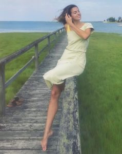 Maddie Sitting on a dock in a green Free People Midi Dress