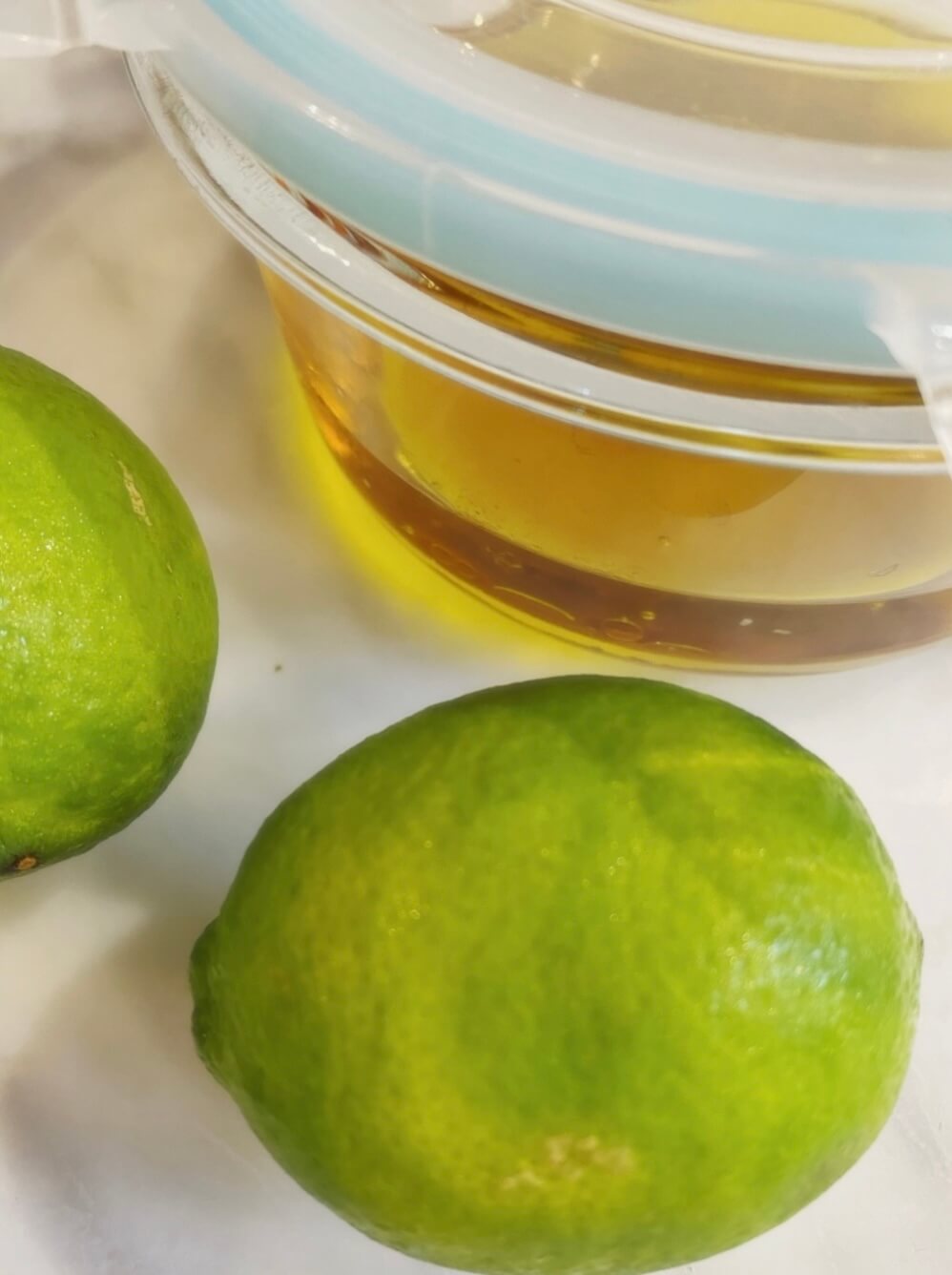 Close up of Limes with Vinaigrette in Tupperware