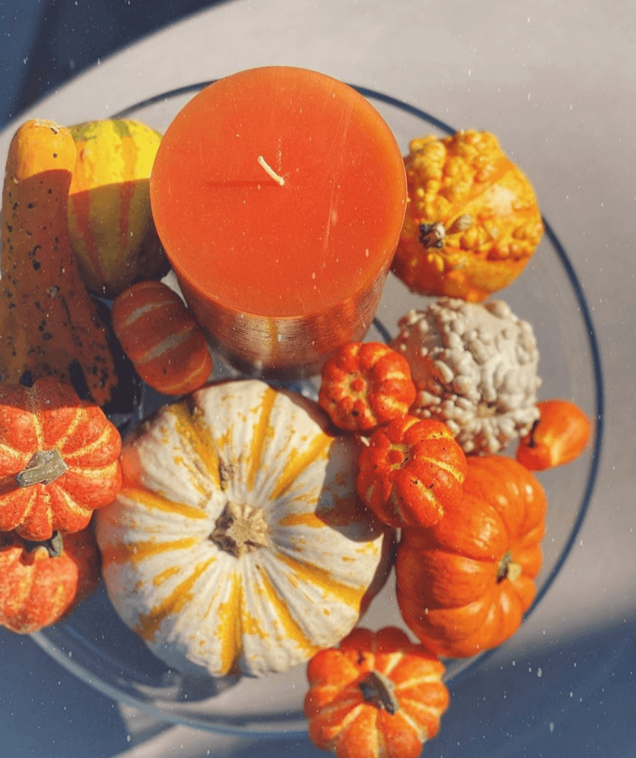 Image of an Orange Candle with decorative pumpkin surrounding it