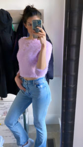 Image of Maddie taking a mirror picture in the denim and a purple fuzzy sweater 