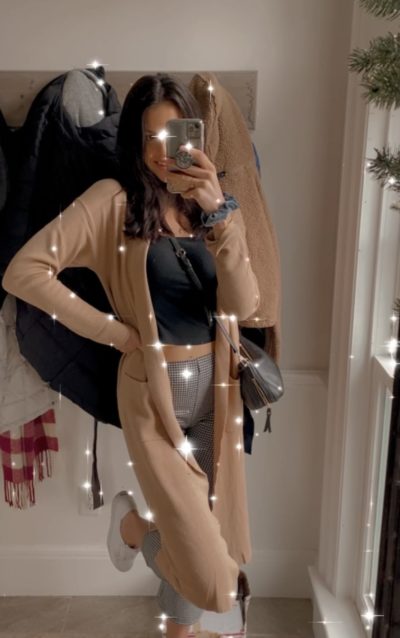 Image of Maddie in a holiday outfit taking a mirror picture 