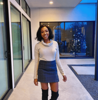 Image Of Sara wearing a skirt with over the knee boots and turteneck sweater