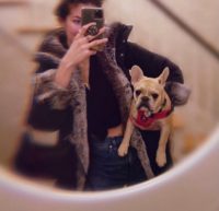 Image of Maddie holding a dog and wearing a faux fur coat