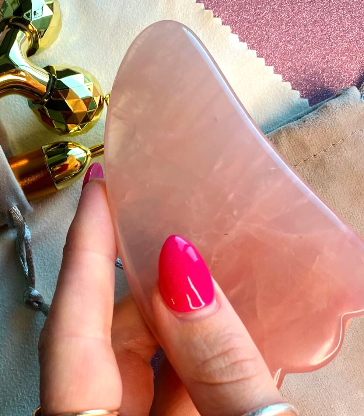 Image of Maddie holding a gua sha beauty tool with the rest of the beauty tools behind it