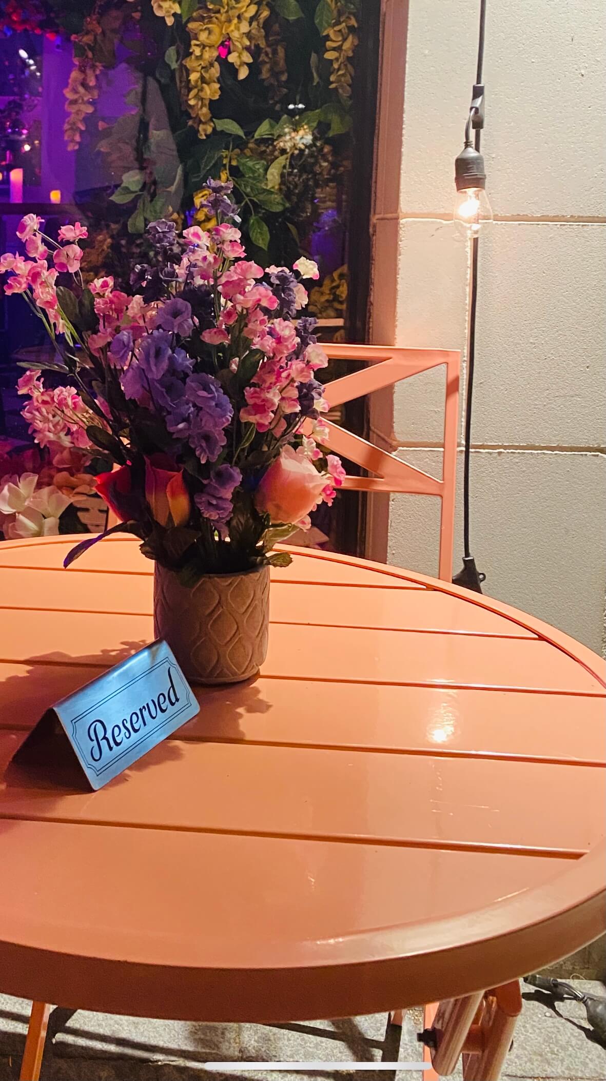 Image of a dinner table with flower and a reserved sign