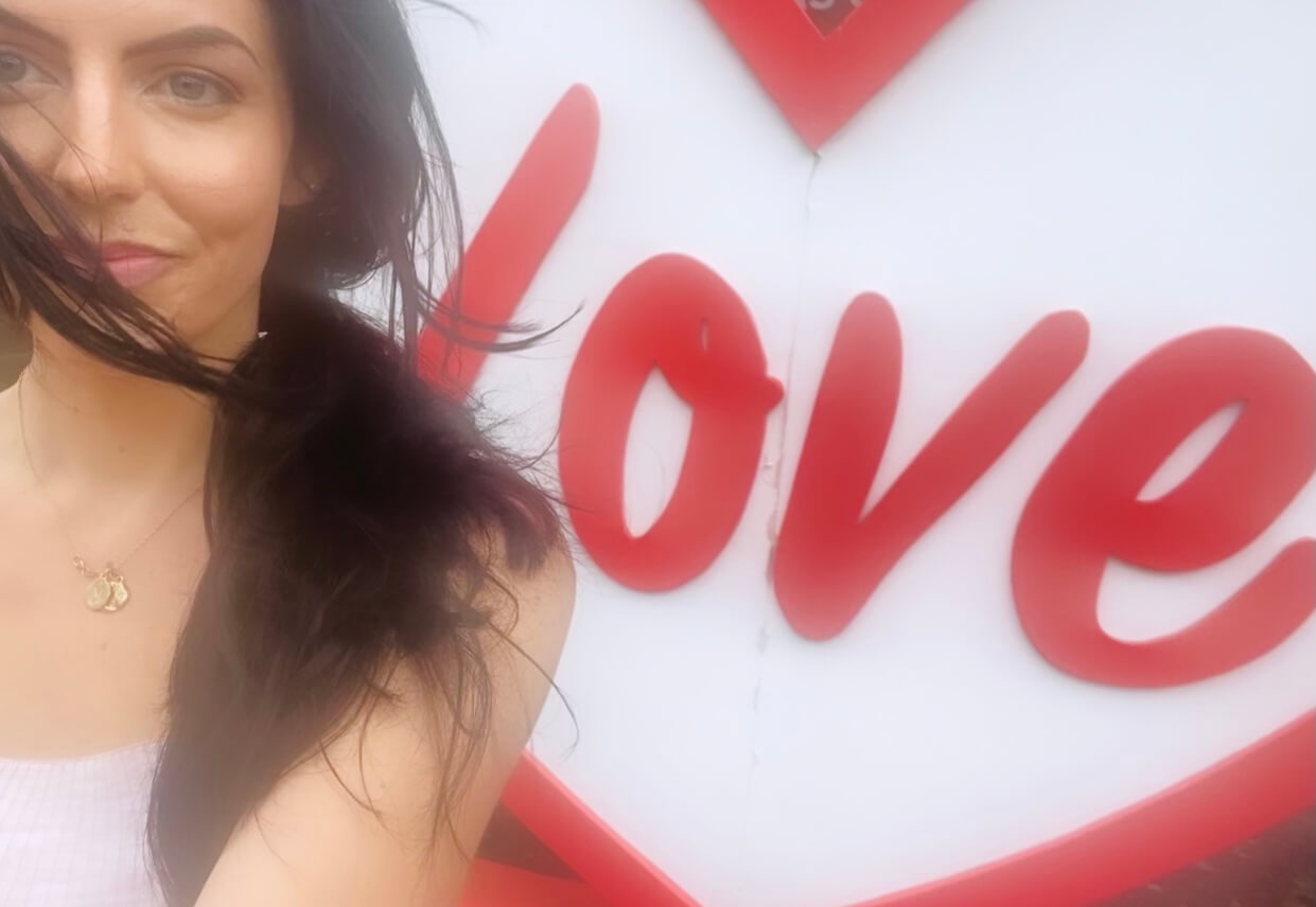 Image of maddie in front of a love sign