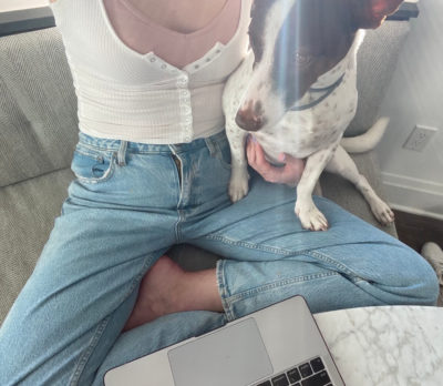 Image of maddie sitting with her dog 